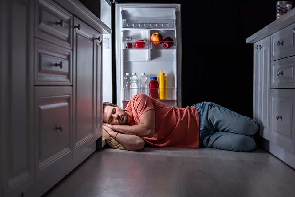 Sleep Cool on a Budget: Affordable Hacks for Hot Sleepers 1 exhausted man sleeping near open refrigerator on k 2023 11 27 04 55 47 utc 1