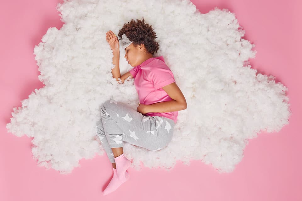 What Side to Lay on When Your Stomach Hurts 1 Sick African American woman cannot sleep because of strong pain in belly suffers from stomachache indigestion feels unwell dressed in pajama poses on white cloud. Health problems and sleeping concept